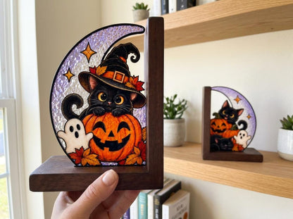 Black Cat Pumpkin Halloween glass bookend set near a bright window